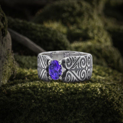 Handcrafted 925 silver Viking ring with intricate scrollwork and an oval purple gemstone.