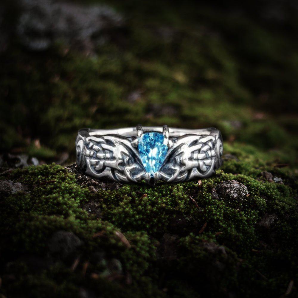 Sterling silver Viking ring with intricate Nordic knotwork and a central blue teardrop gemstone.