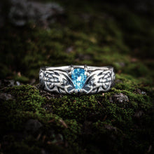 Sterling silver Viking ring with intricate Nordic knotwork and a central blue teardrop gemstone.