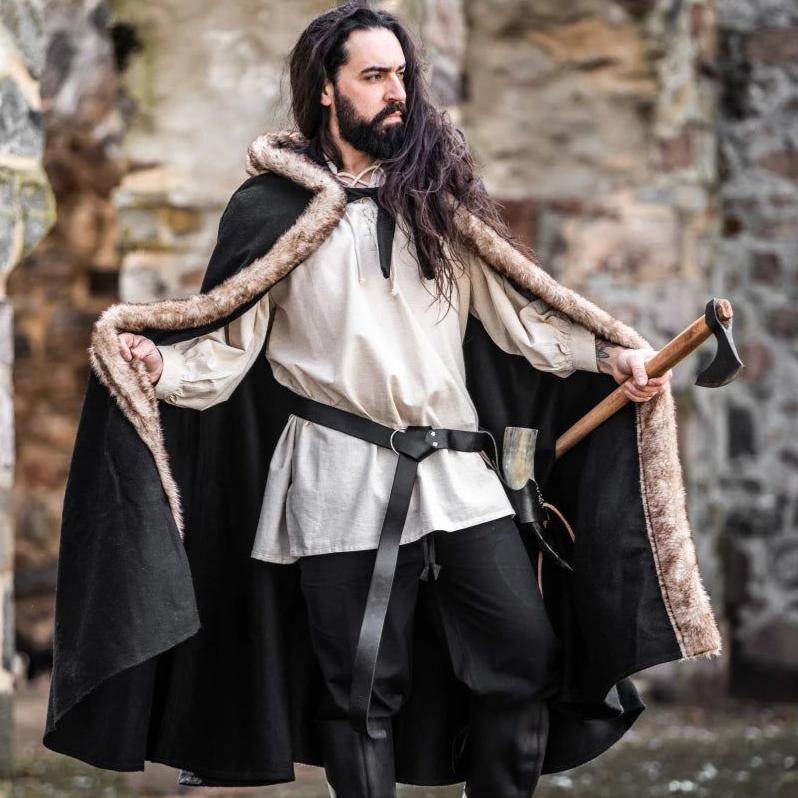 Viking man in black hooded cloak with brown faux fur trim, holding an axe.