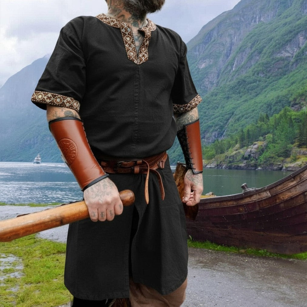 Black Viking tunic with short sleeves, embroidered border, and brown leather bracers.