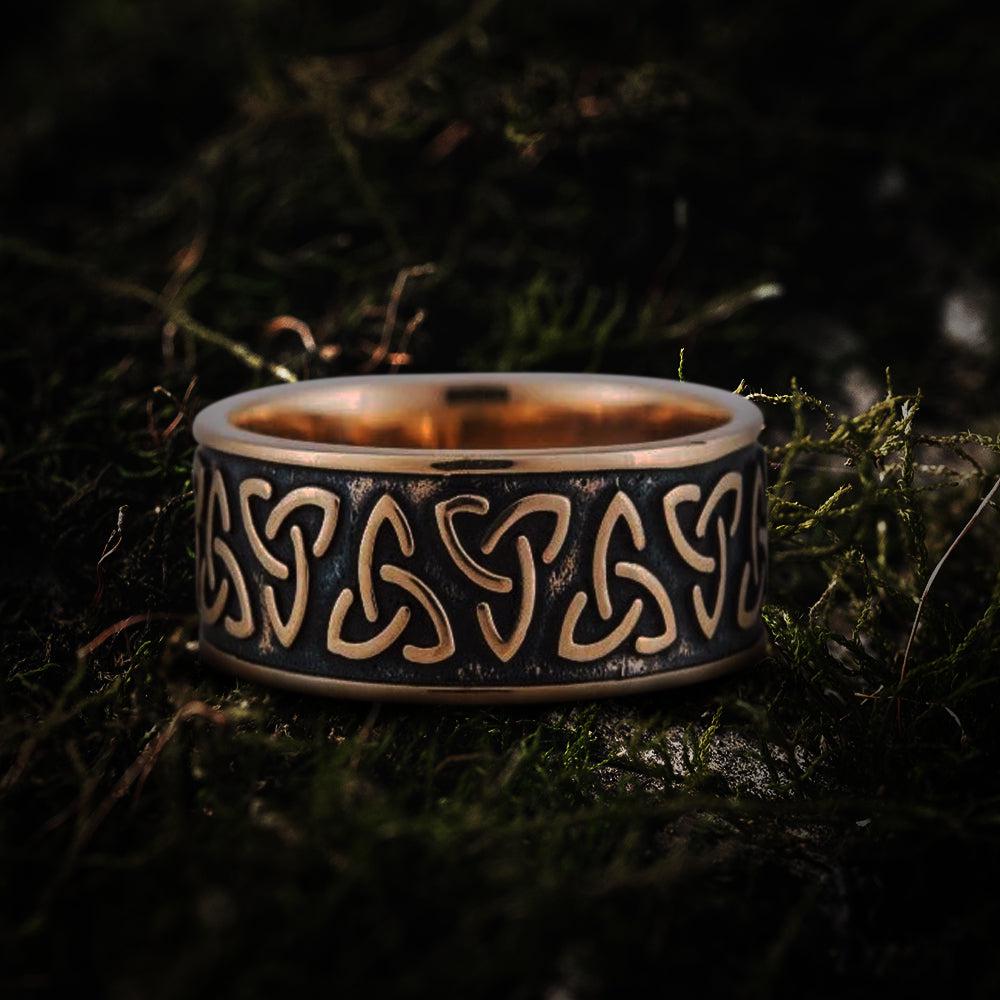 Bronze Viking Triquetra Norse ring with dark patina, showcasing intricate Celtic knotwork on moss.