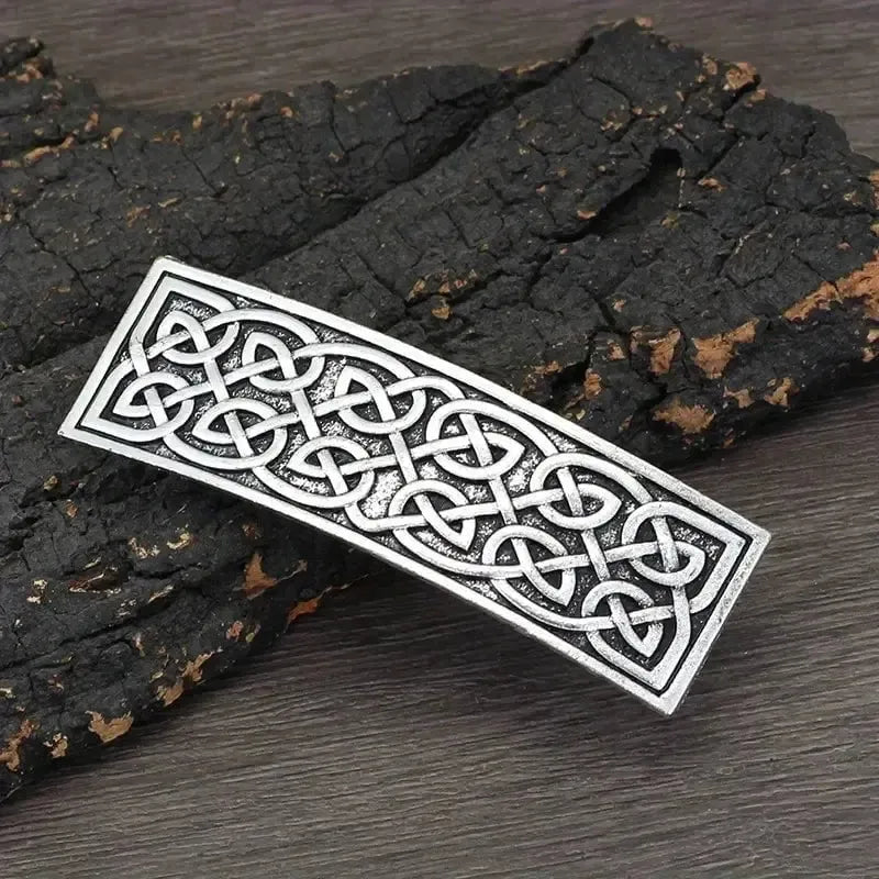 Silver Viking Celtic knotwork hair clip barrette on dark wood.