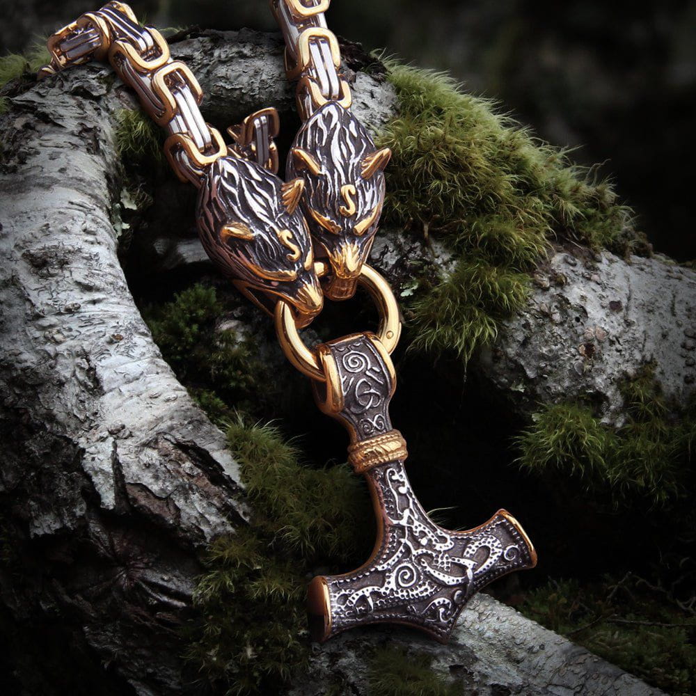 Viking Fenrir wolf heads in gold and steel holding a Mjolnir pendant on a King's Chain.