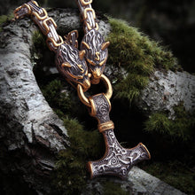 Viking Fenrir wolf heads in gold and steel holding a Mjolnir pendant on a King's Chain.