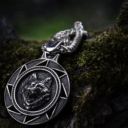 Steel Viking Fenrir wolf medallion necklace on mossy wood.