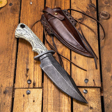 Viking-style knife with a textured white handle and dark blade, beside a brown genuine leather scabbard.