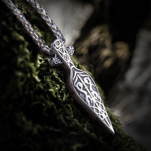 Silver Viking spearhead necklace with intricate knotwork design on a mossy surface.