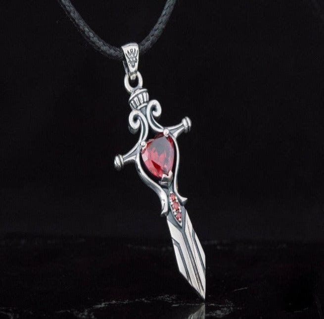 Sterling silver Viking sword pendant with a large heart-shaped red cubic zirconia and smaller red stones.