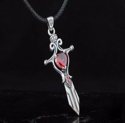 Sterling silver Viking sword pendant with a large heart-shaped red cubic zirconia and smaller red stones.