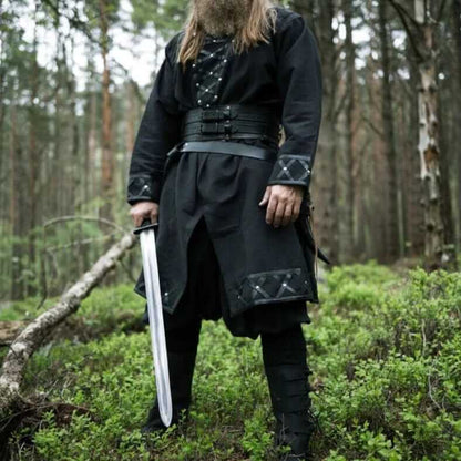 Black Viking tunic with leather trim, rivets, and decorative stitching, worn by a bearded man holding a sword.
