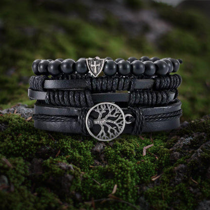 Viking black leather multi-layer bracelet with Yggdrasil charm and shield bead on moss.