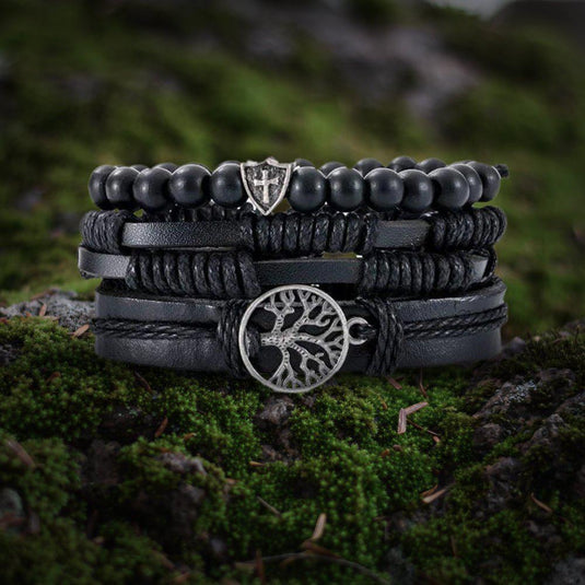 Viking black leather multi-layer bracelet with Yggdrasil charm and shield bead on moss.
