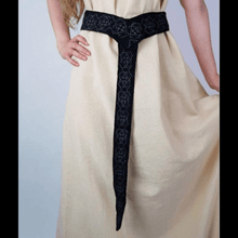 Black cotton Viking belt with intricate embroidered pattern, tied over a cream tunic.