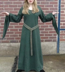 Woman in a long, dark green Viking cotton dress with a light green woven belt.