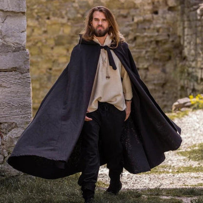 Man in long black wool hooded Viking cloak with front tie closure.
