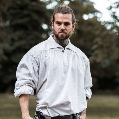 Man in a loose, light gray Viking shirt with a collar and V-neck design.