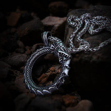 Silver Viking Jormungandr Ouroboros dragon pendant necklace on a dark rocky surface.