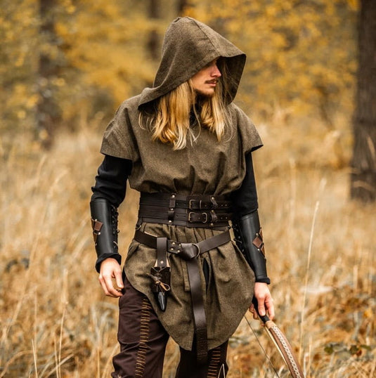Viking-style hooded green tunic with leather belt, bracers, and bow in a forest.