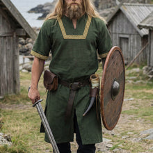 Green Viking tunic with gold trim, short sleeves, worn by a man with a sword, shield, and drinking horn.