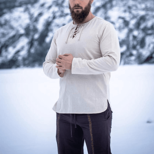 Natural cotton Viking tunic with long sleeves and lace-up collar, worn by a man in snow.