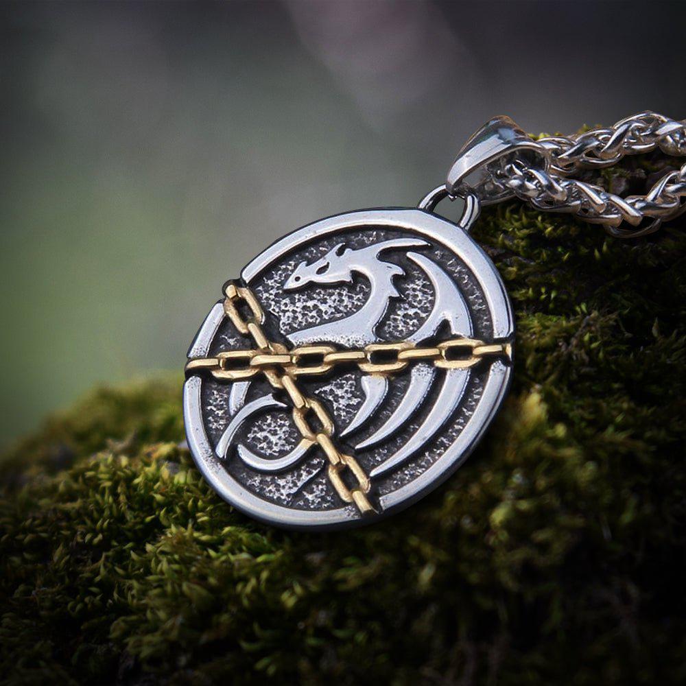 Viking Norse chained dragon talisman pendant in silver and gold-tone, on a thick silver chain.