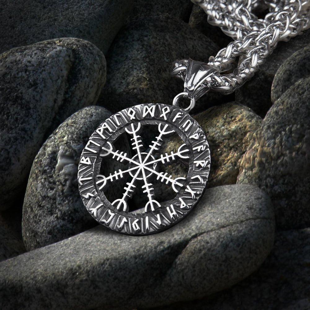 Silver Viking Helm of Awe Futhark amulet necklace on dark grey rocks.