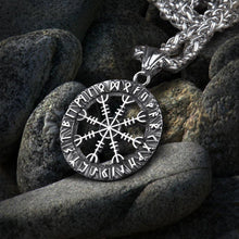 Silver Viking Helm of Awe Futhark amulet necklace on dark grey rocks.