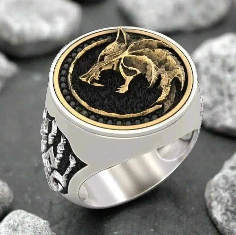 Silver Viking ring with a gold Fenrir wolf head on a black background, surrounded by black stones.