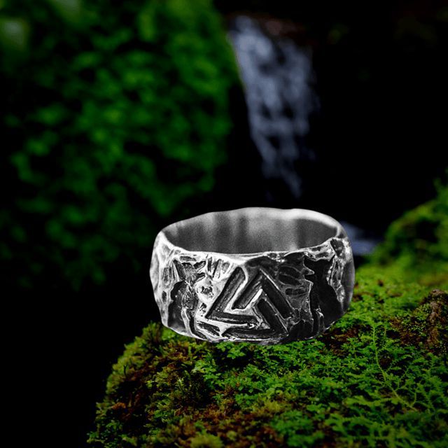 Viking stainless steel ring with Valknut and wolves Hati and Skoll design on mossy rock.