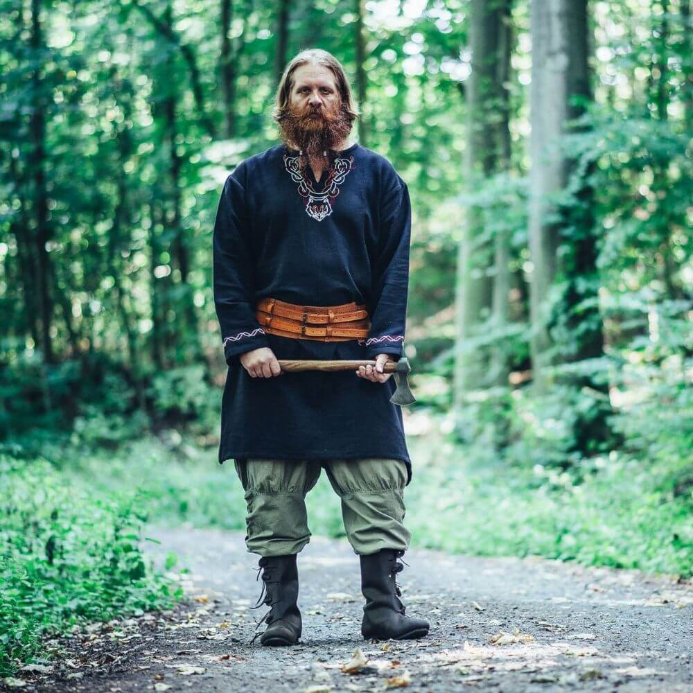 Premium Viking Pants in Hemp with crisscross drawstring, styled with a tunic, leather belt, and Viking axe in forest.