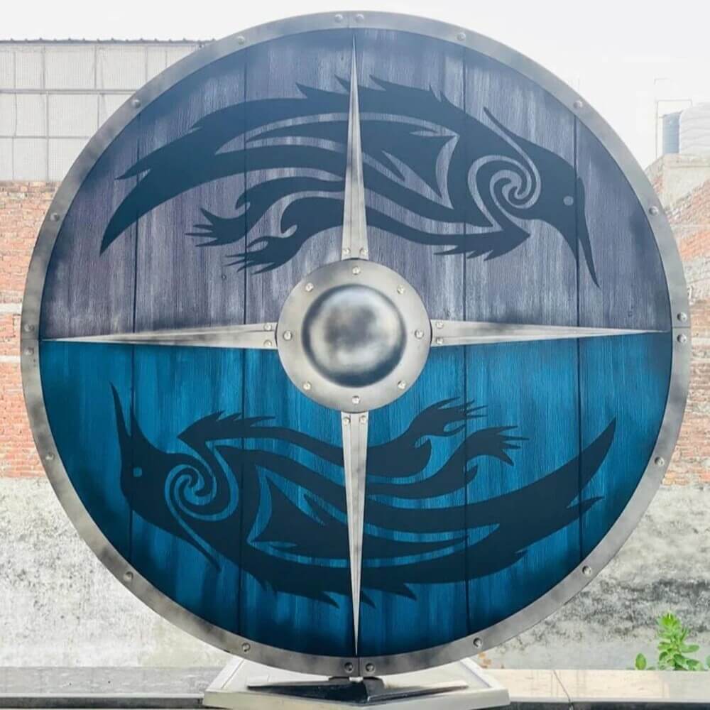 24" round wooden Viking shield with blue and gray panels, featuring black raven designs and a metal boss.