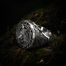 Silver Viking wolf head totem ring with intricate geometric patterns on moss.