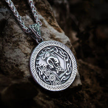 Stainless steel Viking dragon necklace with intricate Celtic knotwork design on a dark rock.