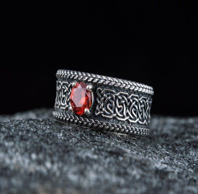 Sterling silver Viking ring with intricate Celtic knotwork and a vibrant red gemstone.