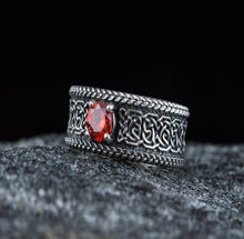 Sterling silver Viking ring with intricate Celtic knotwork and a vibrant red gemstone.