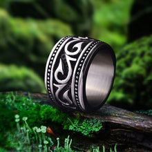 Wide titanium steel Viking ring with intricate Nordic swirl and dot patterns.