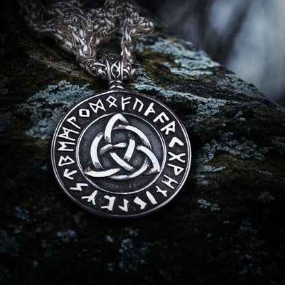 Viking silver Triquetra Futhark rune eternity necklace with intricate knotwork on a dark, textured surface.