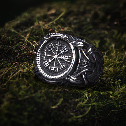 Viking Vegvisir compass ring in dark steel with Jormungandr knotwork on moss.