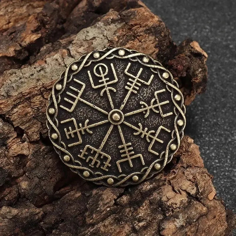 Bronze Viking Vegvisir compass brooch with Norse protection symbols on bark.