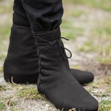 Black low-cut Viking boots with lace-tied faux leather, worn over pants.