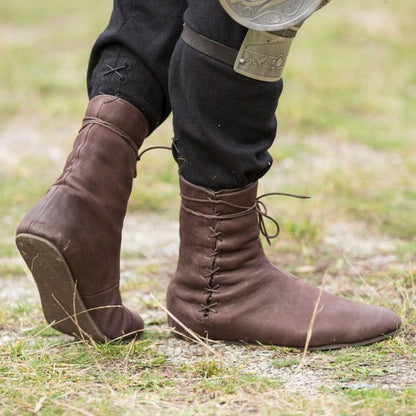 Brown faux leather Viking boots, low-cut and lace-tied, worn on grass.