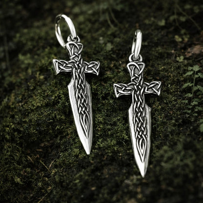 Viking Celtic cross blade drop earrings in silver, featuring intricate knotwork on a mossy background.