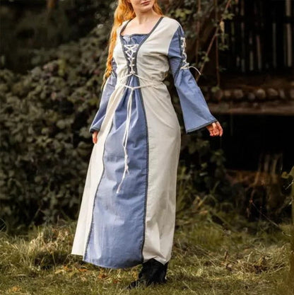 Viking natural and blue dress with borders and laces, worn by a woman outdoors.
