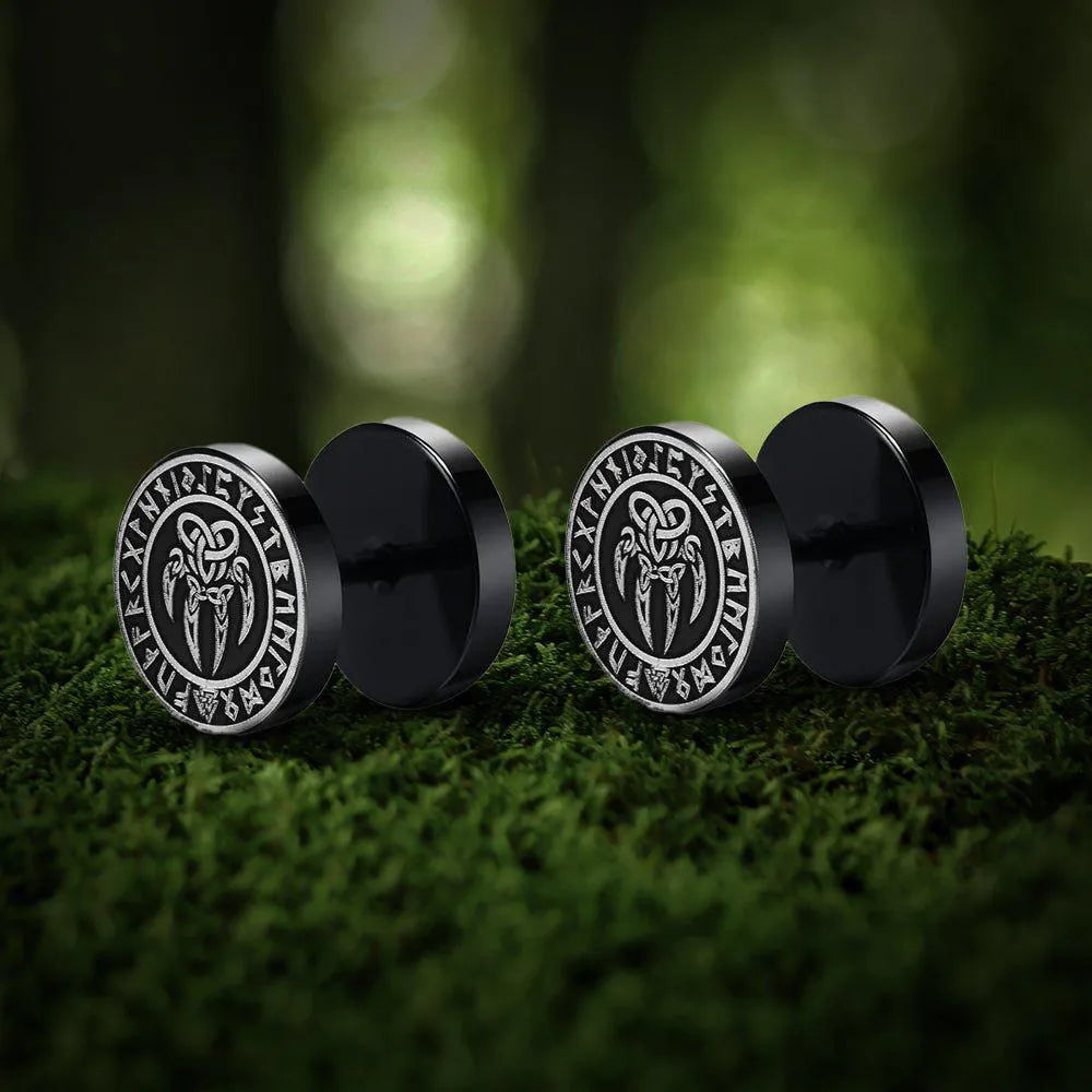 Black Viking stud earrings with a silver Norse bear claw symbol on moss.