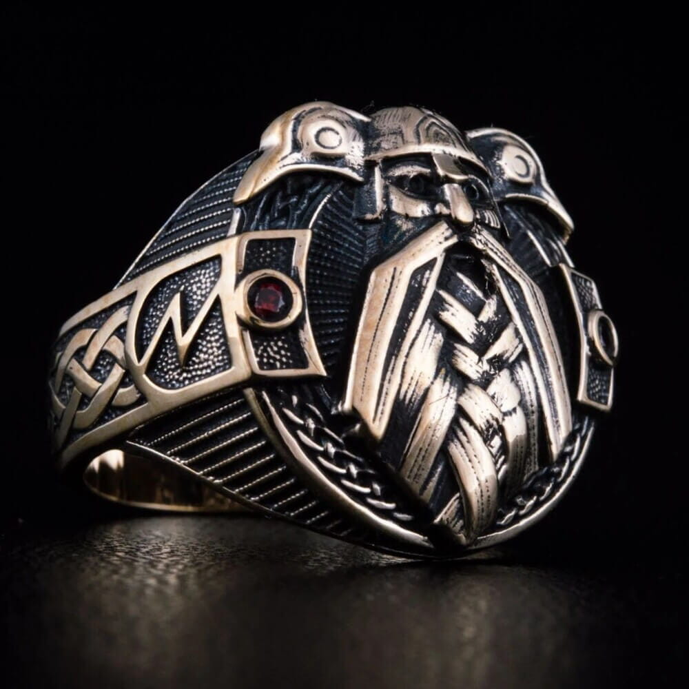 Viking Odin ring in bronze with intricate raven and knotwork details, featuring red gemstones.