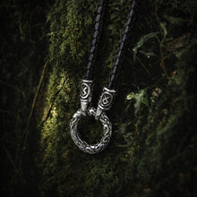 Viking silver ring pendant on a black braided cord necklace, featuring intricate Celtic knotwork.