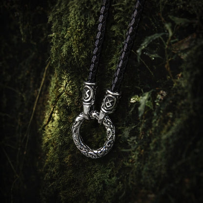 Viking silver ring pendant on a black braided cord necklace, featuring intricate Celtic knotwork.