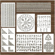 White Viking rune stencils with Norse symbols, Celtic borders, and alphabet designs on a wooden background.