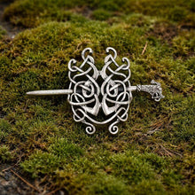 Viking silver serpent knot hair clip with intricate Celtic design and dragon head pin, on moss.